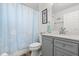 Bathroom featuring stylish vanity, shower with seashell curtain, and attractive blue and white accents at 1904 Rouzbeh Ct, Port Orange, FL 32128