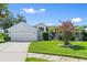Well-maintained home with manicured lawn, mature tree, and attached two-car garage at 1904 Rouzbeh Ct, Port Orange, FL 32128