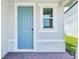 Close up on an inviting light blue front door with white trim and brick pavers at 288 Links Terrace Blvd, Daytona Beach, FL 32124
