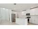 Modern kitchen features white cabinets, stainless steel appliances, and a center island at 288 Links Terrace Blvd, Daytona Beach, FL 32124