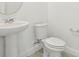 The well-lit powder room showcases a pedestal sink and a modern, water-conserving toilet at 288 Links Terrace Blvd, Daytona Beach, FL 32124