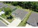 Aerial view of a gray home with a long driveway, green lawn, landscaping, and surrounding trees at 3029 Adrian Dr, Ormond Beach, FL 32174