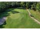 Aerial view of the golf course with green, fairway and path and sand bunkers, with cart at 3029 Adrian Dr, Ormond Beach, FL 32174