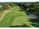 Aerial view of golf course, showing green, fairway, sand bunkers, and a cart path at 3029 Adrian Dr, Ormond Beach, FL 32174