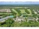 Aerial view of the community, showcasing the golf course, swimming pool, tennis courts, and surrounding landscape at 3029 Adrian Dr, Ormond Beach, FL 32174