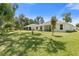 Expansive backyard showing the home's exterior with ample green space and mature trees at 3029 Adrian Dr, Ormond Beach, FL 32174
