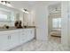Bright bathroom features double vanity, modern fixtures, marble floors and view into an adjacent bedroom at 3029 Adrian Dr, Ormond Beach, FL 32174