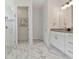 Modern bathroom showcasing marble floors, glass shower, and white vanity with stylish fixtures at 3029 Adrian Dr, Ormond Beach, FL 32174
