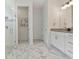 Bathroom with marble floors, walk-in shower, granite counter, and stylish wall mirror at 3029 Adrian Dr, Ormond Beach, FL 32174