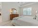 Bright bedroom featuring a wooden dresser, comfortable bed, and natural light from the window at 3029 Adrian Dr, Ormond Beach, FL 32174