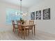 Cozy dining room showcasing a modern light fixture, wooden table, and stylish botanical artwork at 3029 Adrian Dr, Ormond Beach, FL 32174