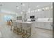 A bright kitchen features a quartz island with seating, complemented by white cabinetry and pendant lighting at 3029 Adrian Dr, Ormond Beach, FL 32174