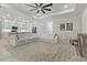 Spacious living room featuring a large white sectional, ceiling fan, and an open-concept design with a view of the kitchen at 3029 Adrian Dr, Ormond Beach, FL 32174