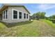 Charming backyard view of home with windows, lush green grass and pond at 920 N Lakewood Ter, Port Orange, FL 32127