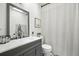 Updated bathroom features gray vanity, framed mirror, and shower with white curtain at 920 N Lakewood Ter, Port Orange, FL 32127
