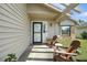 Inviting front porch features neutral siding, stone accents, and wooden chairs for relaxing outdoors at 920 N Lakewood Ter, Port Orange, FL 32127