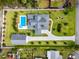 Aerial view of a landscaped property featuring a pool, manicured lawn, and patterned driveway at 96 Grove St, Ormond Beach, FL 32174