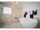 Bright bathroom featuring a freestanding tub, glass enclosed shower, and black and white patterned floor at 96 Grove St, Ormond Beach, FL 32174