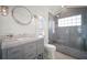Modern bathroom featuring a gray vanity with marble top and glass enclosed shower with pebble floor at 96 Grove St, Ormond Beach, FL 32174