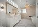 Luxury bathroom with dual sinks, soaking tub, walk-in shower, and stylish black and white tile floor at 96 Grove St, Ormond Beach, FL 32174