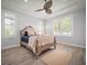Neutral bedroom with a decorative ceiling fan, a large bed, and windows with plantation shutters at 96 Grove St, Ormond Beach, FL 32174