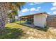 View of the backyard featuring a covered patio area, surrounded by greenery and a wood fence at 1 Beechwood Dr, Ormond Beach, FL 32176