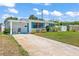 Charming single-story home featuring a well-maintained lawn, cozy carport, and vibrant turquoise shutters at 1 Beechwood Dr, Ormond Beach, FL 32176