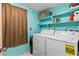 Functional laundry room featuring a washer, dryer, shelving, and painted walls at 1 Beechwood Dr, Ormond Beach, FL 32176