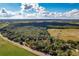 Aerial view of a lot near a road, surrounded by lush trees and open fields at 1544 S Us 301, Sumterville, FL 33585
