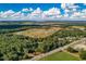 Aerial view showing a large lot of land with surrounding trees and fields at 1544 S Us 301, Sumterville, FL 33585