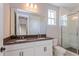 Bathroom features a double vanity with dark countertop and a glass shower at 9762 Neruda St, Orlando, FL 32827