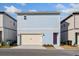 Two-story home with light blue siding, beige trim, front-entry garage, and a purple front door at 9762 Neruda St, Orlando, FL 32827