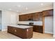 The open-concept kitchen features dark wood cabinets, stainless steel appliances, and an island at 9762 Neruda St, Orlando, FL 32827
