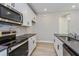 Well-lit kitchen features stainless steel appliances, gray backsplash and dark countertop at 9762 Neruda St, Orlando, FL 32827