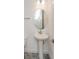 Elegant powder room featuring pedestal sink and stylish mirror at 10185 Pearson Ave, Orlando, FL 32827