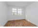 Well-lit bedroom with wood flooring and two windows at 10185 Pearson Ave, Orlando, FL 32827