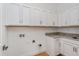 Bright laundry room with white cabinets and granite countertops at 10185 Pearson Ave, Orlando, FL 32827