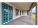 Inviting covered porch with teal doors and brick pavers at 10185 Pearson Ave, Orlando, FL 32827