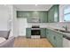 Modern kitchen with green cabinets and stainless steel appliances at 13438 Leggett Aly, Orlando, FL 32827