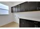 Bright laundry room with dark cabinets and quartz countertops at 13438 Leggett Aly, Orlando, FL 32827