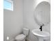 Modern powder room with pedestal sink, toilet, and oval mirror at 13438 Leggett Aly, Orlando, FL 32827