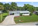 Single-story home with a metal roof, driveway, and lush green lawn at 2734 Vindale Rd, Tavares, FL 32778