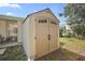 Tan colored storage shed with double doors in the backyard at 2734 Vindale Rd, Tavares, FL 32778