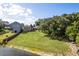 Expansive green backyard featuring a lake view and lush trees at 10120 Lakeshore Dr, Clermont, FL 34711