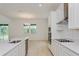 Well-lit kitchen features stainless appliances, white cabinets, and modern countertop at 6370 Trailblaze Bnd, St Cloud, FL 34771