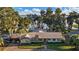 An estate home with mature landscaping, a private lake pier, and a lush green lawn at 1241 W Lakeshore Dr, Clermont, FL 34711
