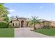 Stunning single-story home showcasing stone accents, a paver driveway, manicured lawn, and lush landscaping at 5418 Meadow Hill Loop, Lady Lake, FL 32159