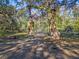 Wrought iron entrance gate flanked by stone pillars, surrounded by mature trees providing an estate-like feel at 13524 Corkwood Ln, Astatula, FL 34705