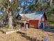 Charming two-story home with a metal roof and a front porch, surrounded by foliage creating privacy at 13524 Corkwood Ln, Astatula, FL 34705