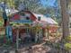 Two-story house with a metal roof and a cozy front porch surrounded by mature trees, offering a quiet escape at 13524 Corkwood Ln, Astatula, FL 34705